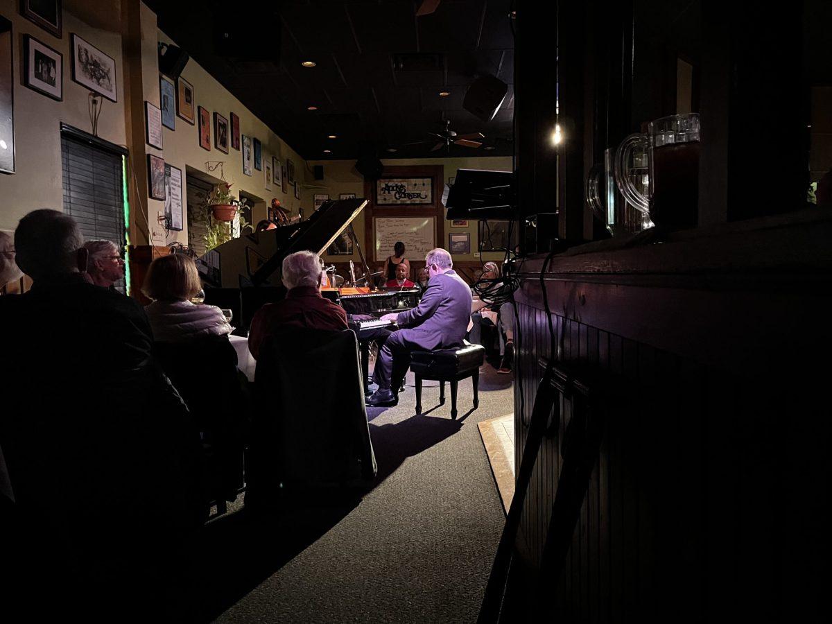 Bill Charlap plays piano under a spotlight.
