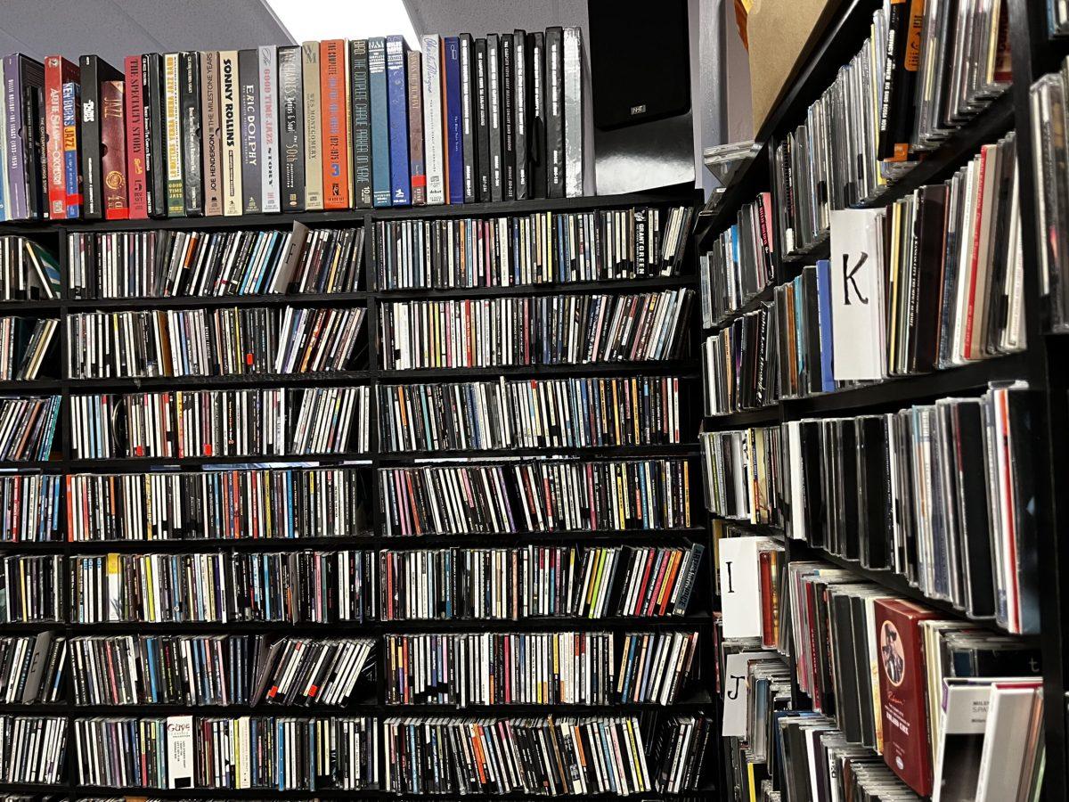 Hundreds CDs are packed into shelves and organized alphabetically.
