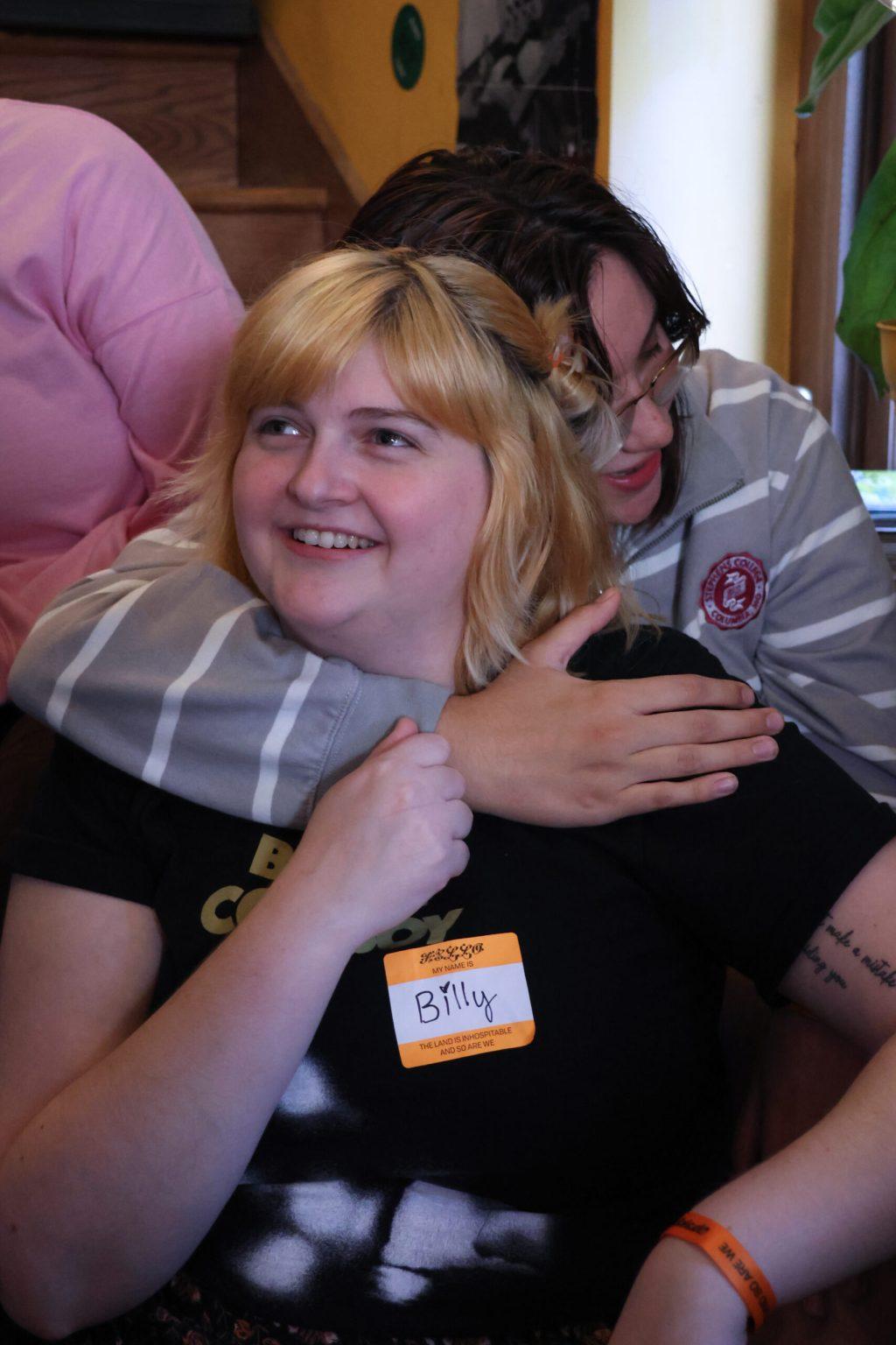 Two people embracing while sitting on a set of stairs at Hitt Records.