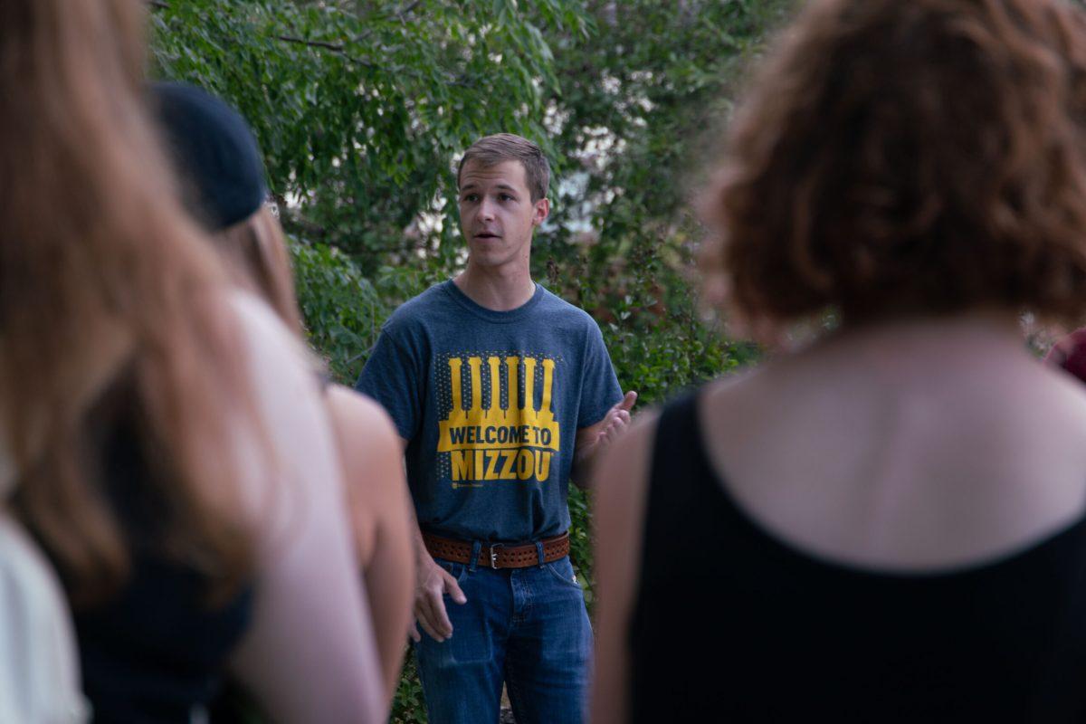 George Frees wears a gray shirt which says “WELCOME TO MIZZOU” while speaking to students. 