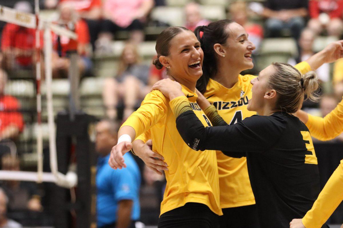 The volleyball team embraces on the court.