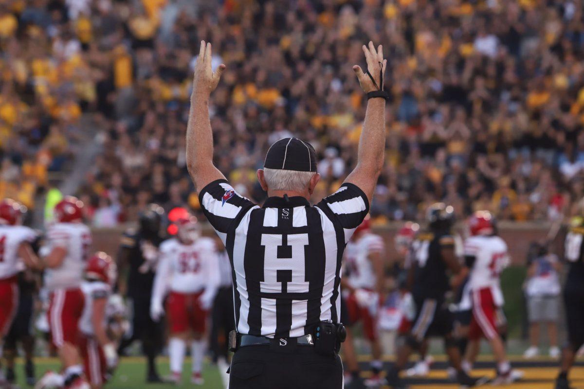 A referee holds his hands up to signal a touchdown.