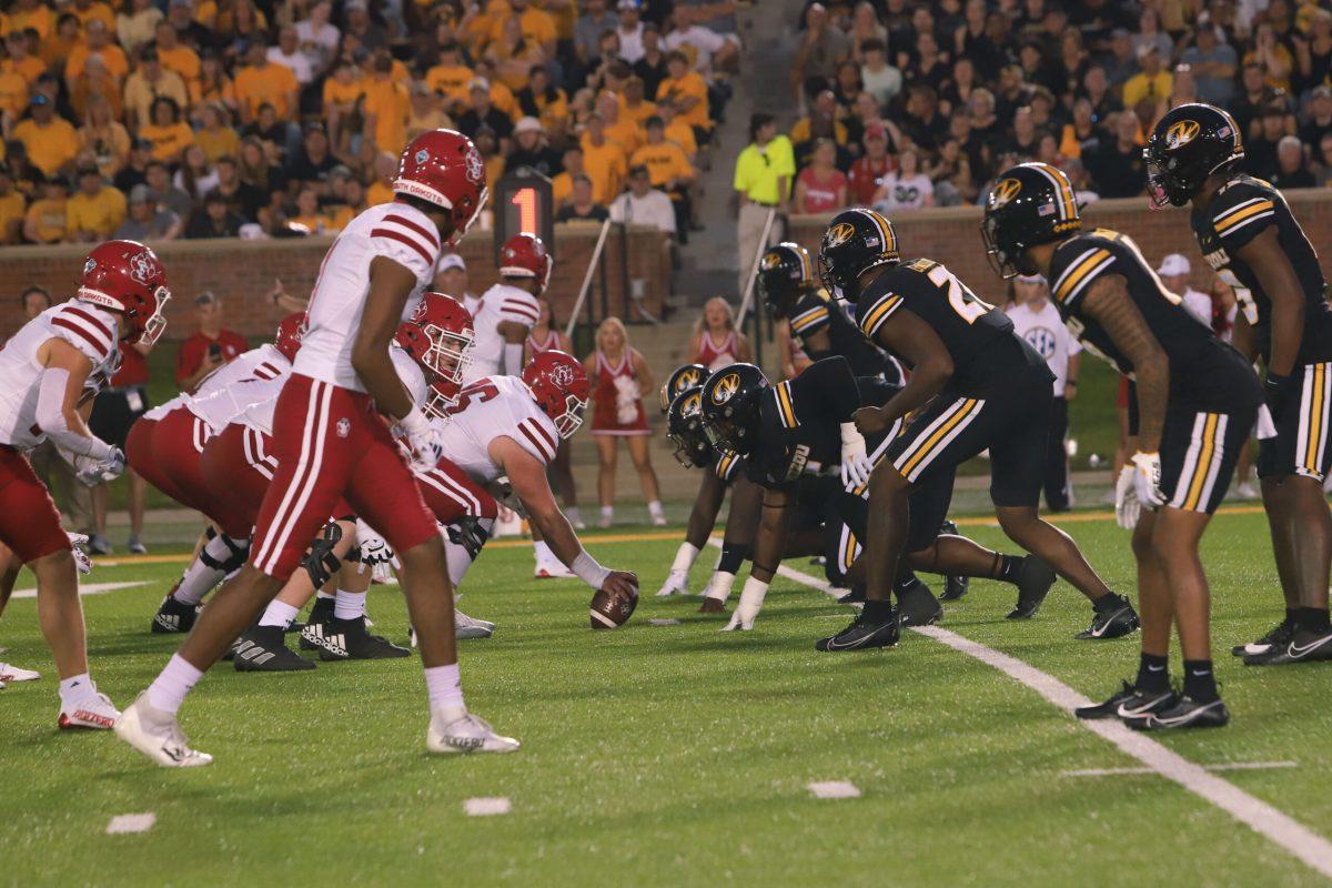 South Dakota and Missouri football players line up before beginning a play.