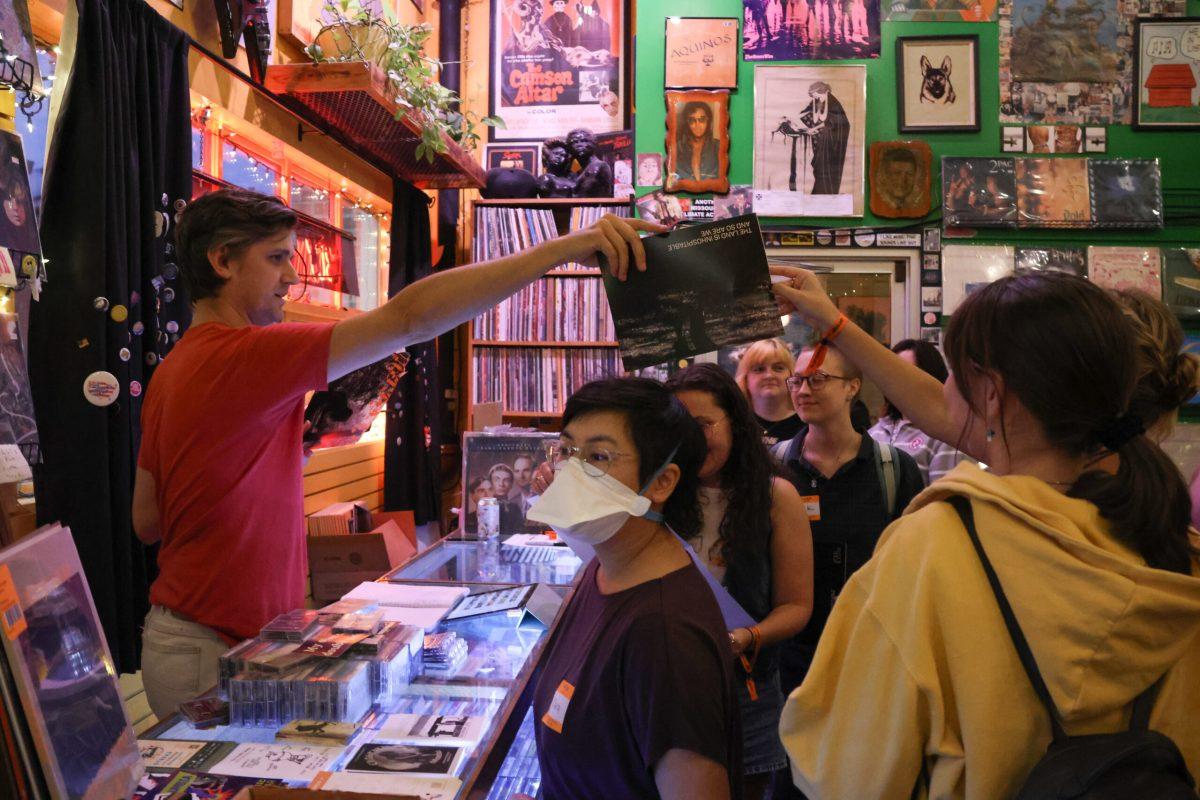 One of the owners of Hitt Records hands a customer a poster.