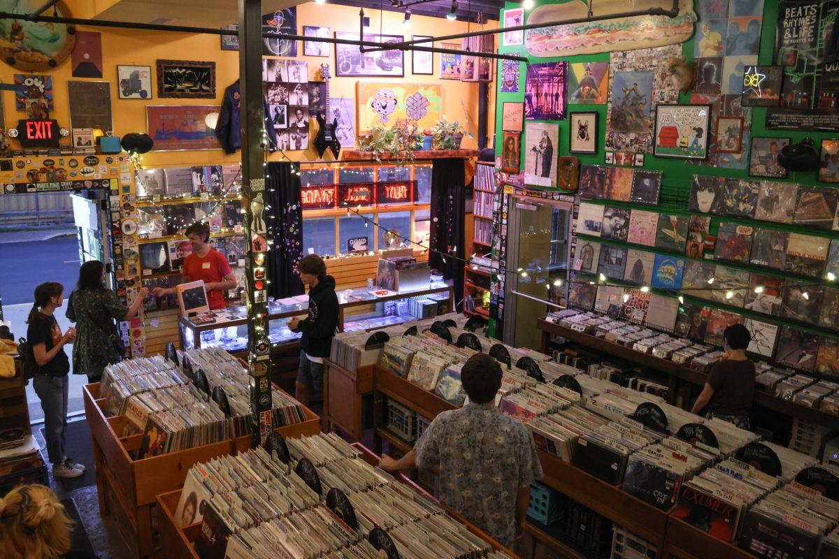 Several people standing in Hitt Records listening to Mitski’s new album