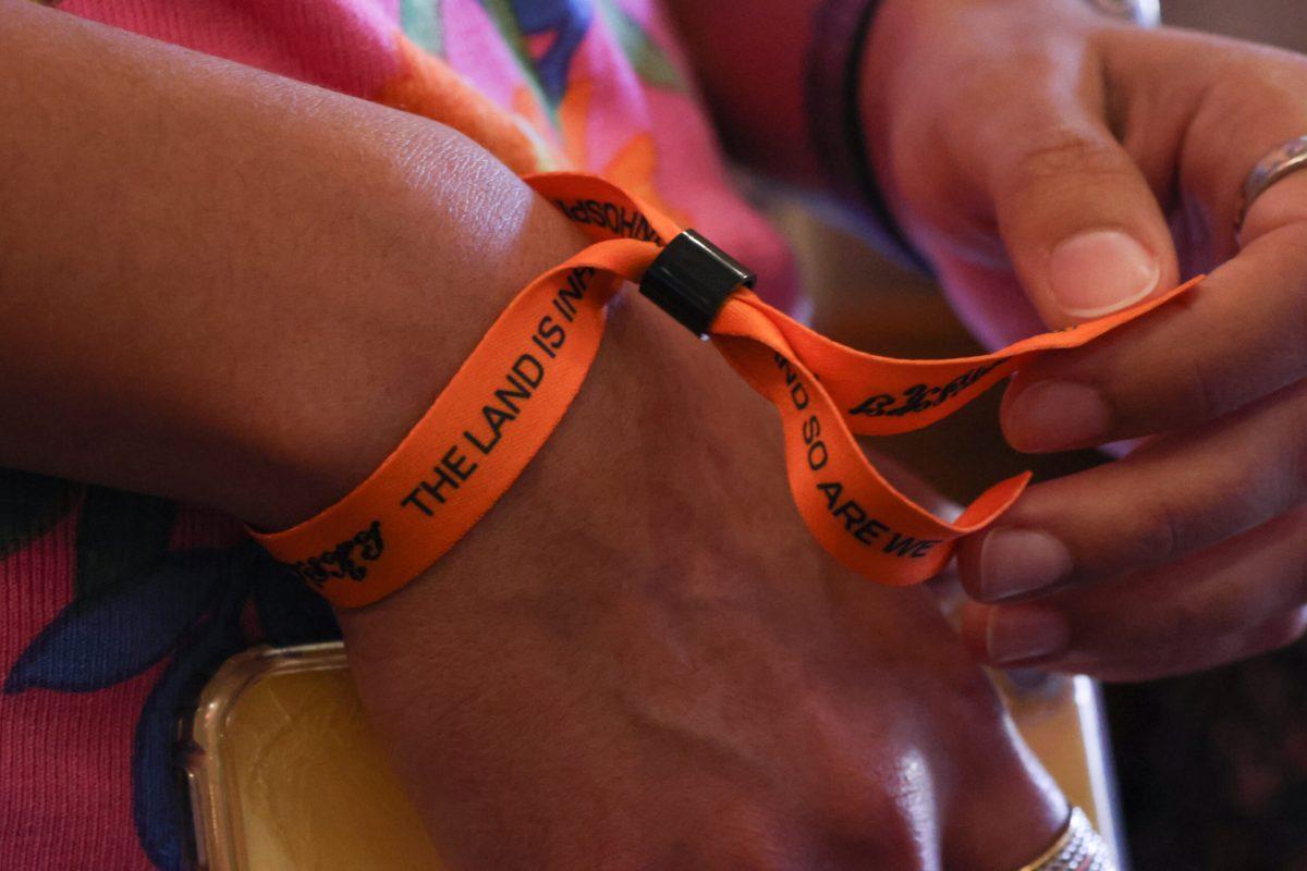A person wearing a wristband with the title of Mitski’s new album on it.