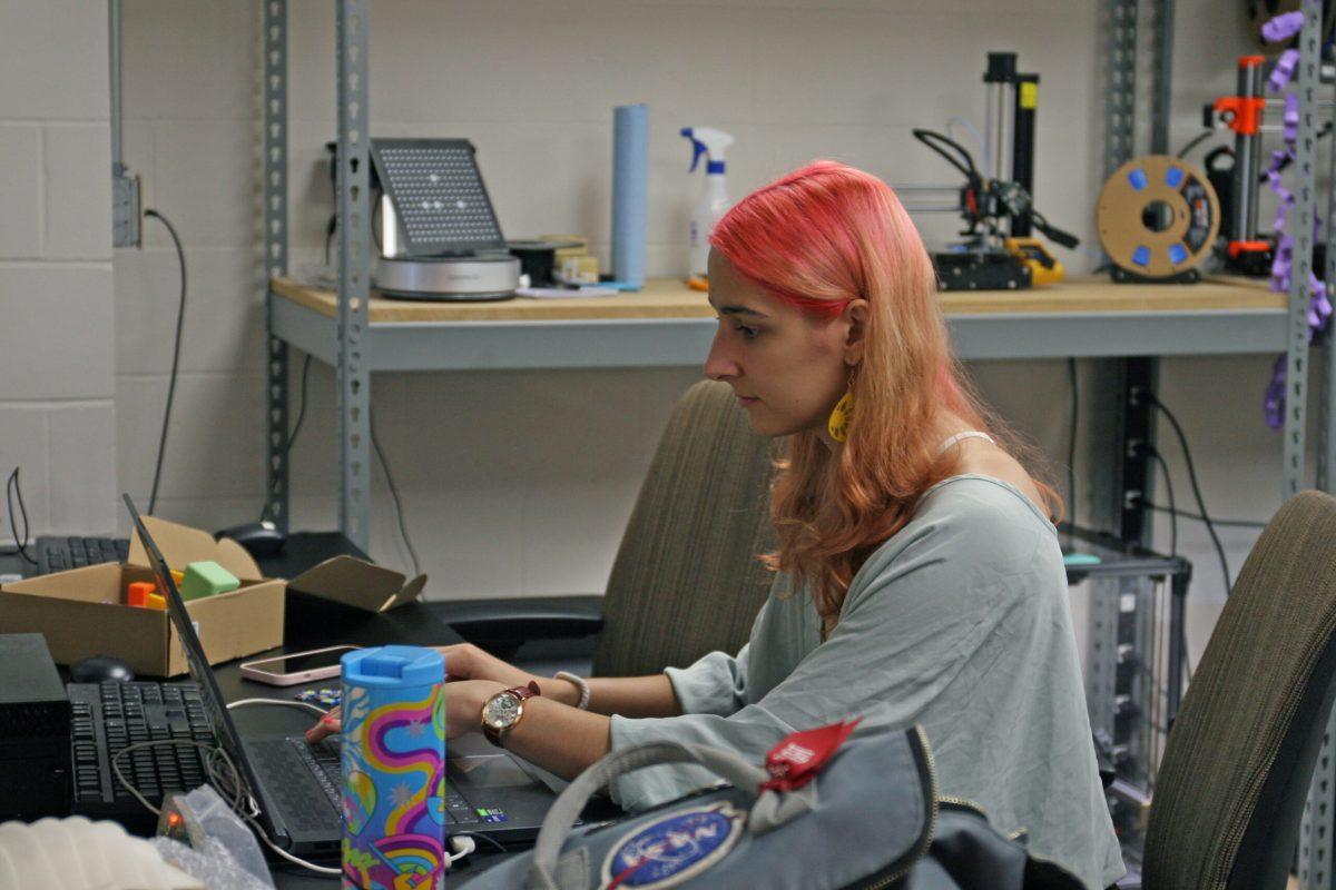 Alina Rohulia sits in Lafferre Hall’s 3D printing lab looking at her computer and working on a design.