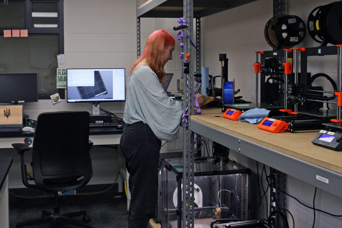 Alina Rohulia stands by a 3D printer and watches as her design is printed in the 3D printing lab in Lafferre Hall.