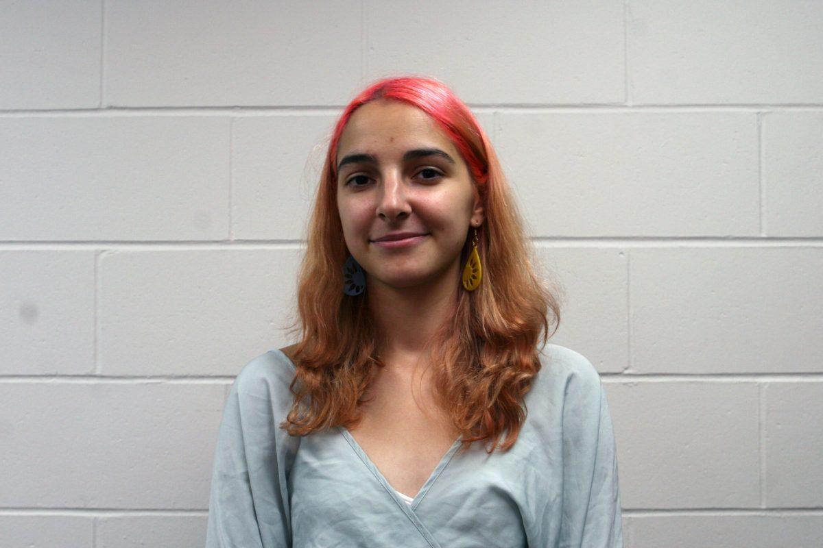 Alina Rohulia stands in the printing lab in front of a white wall and smiles in Lafferre Hall.