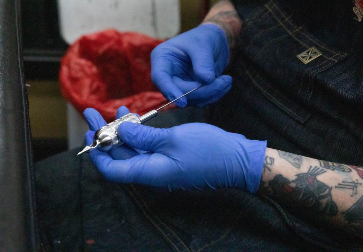 Gabe Garcia loads up his tattoo machine before tattooing his client. 
