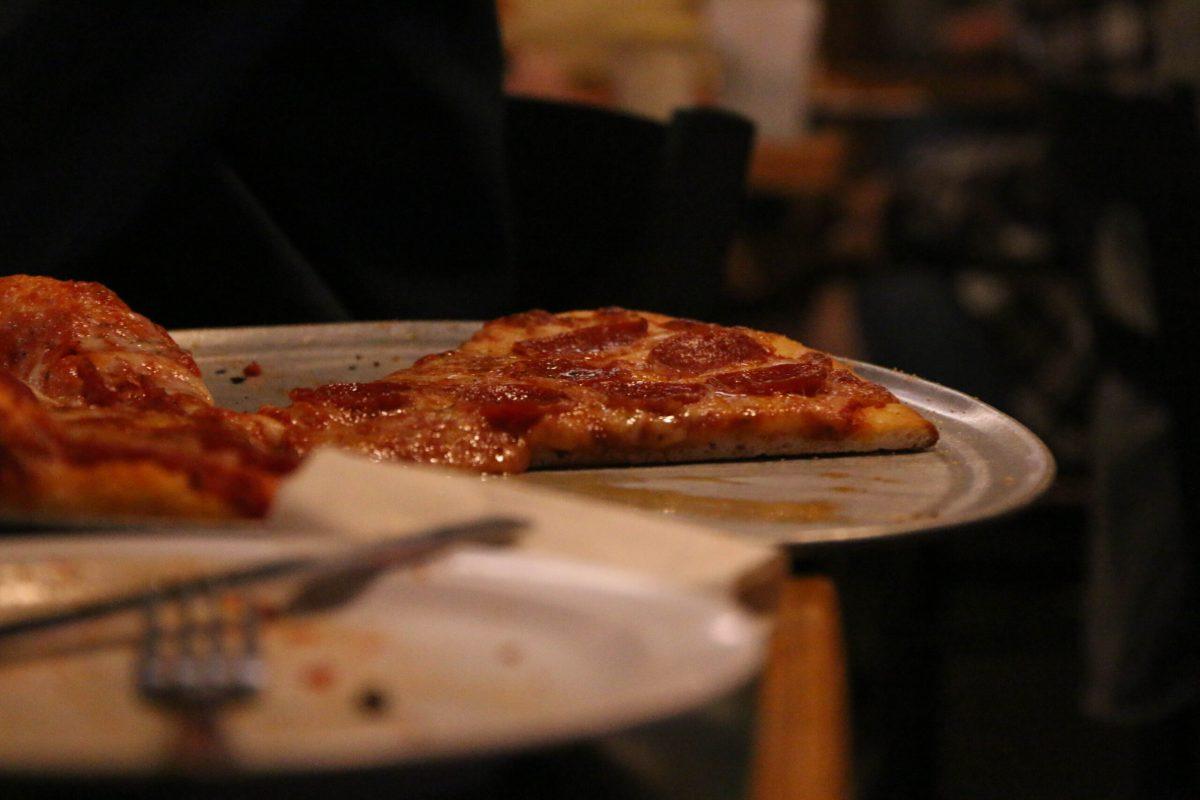 Tray of pizza sitting atop a table.