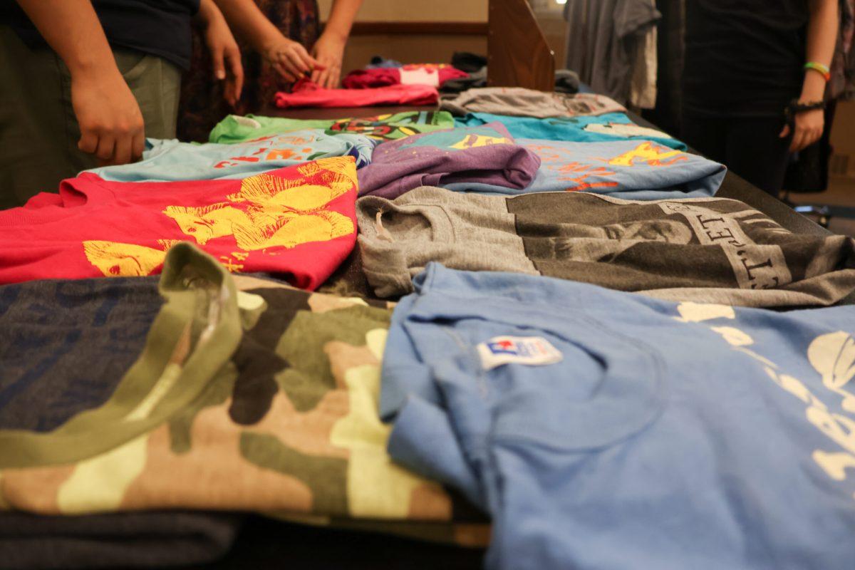 A variety of folded t-shirts resting on a table.