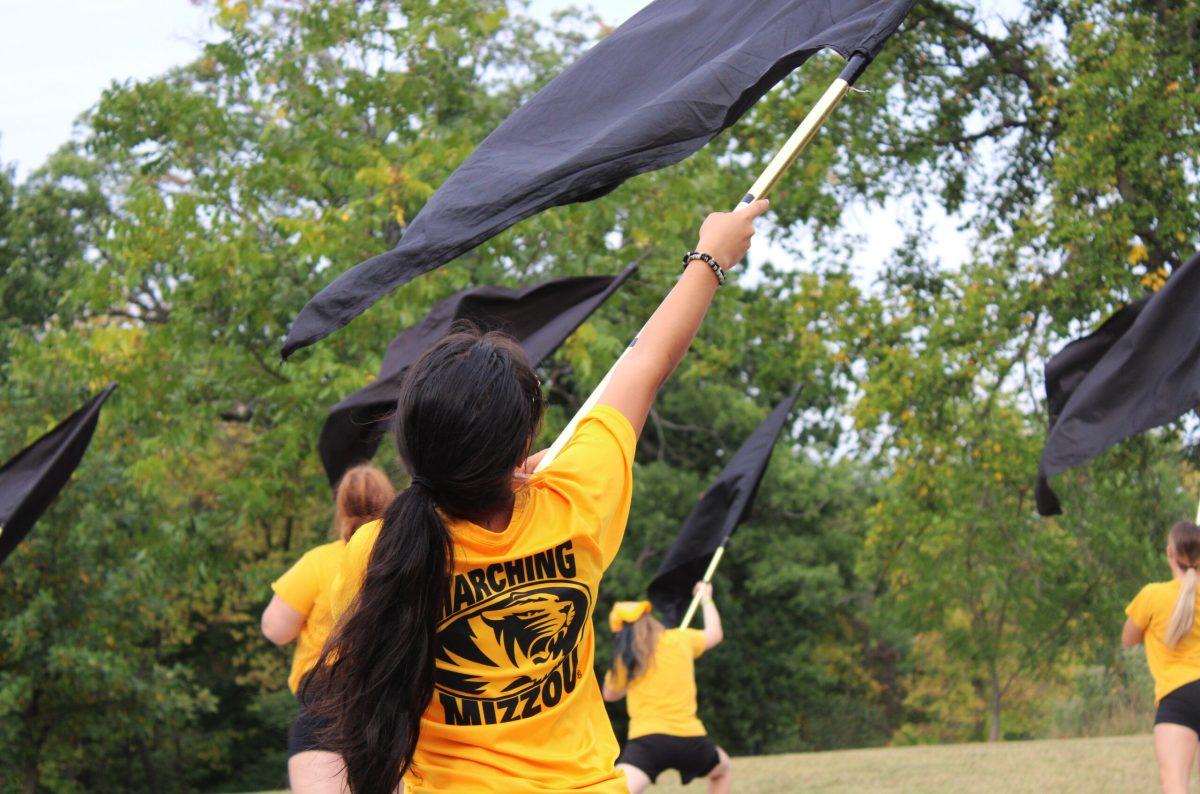 Isabela Cruz finishes flag work with a strong ending pose at the Marching Band practice field.
