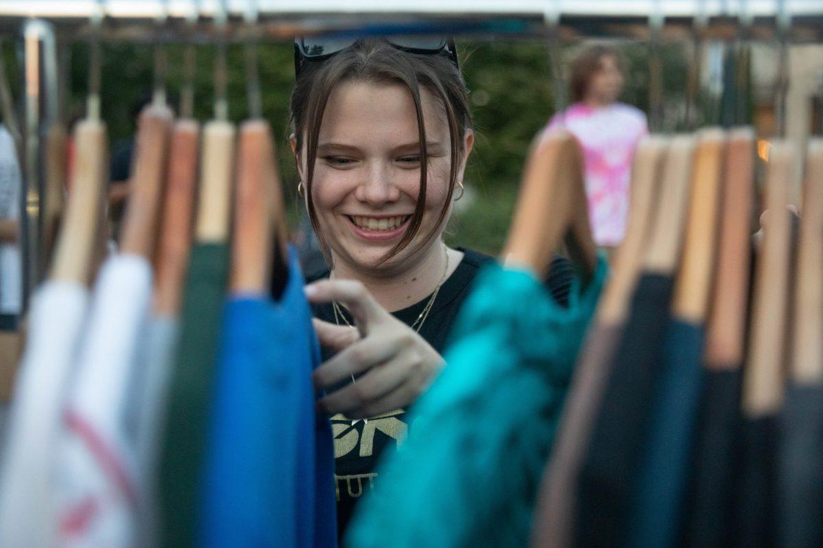 Catherine Lawless flips through a rack of clothes.