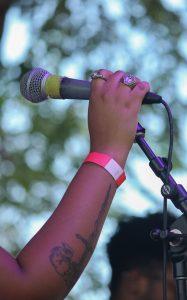 A hand holding onto a microphone.
