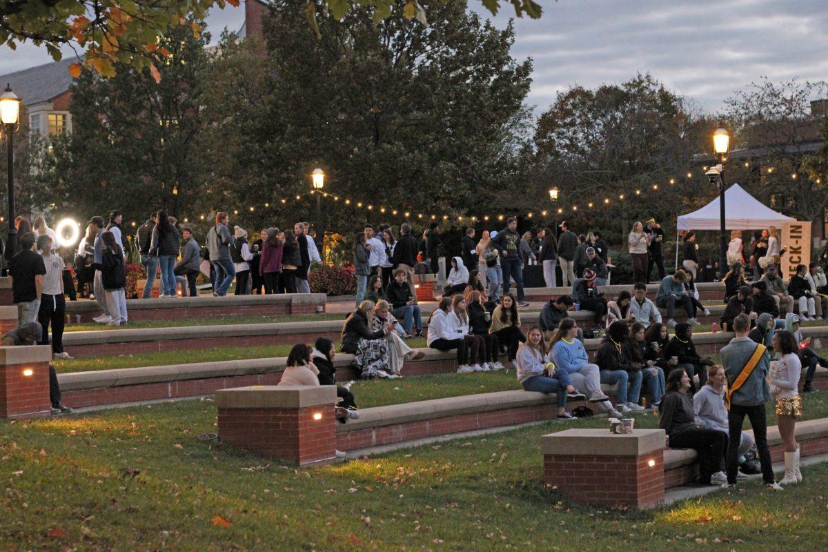 A group of students sitting on the Traditions Plaza steps waiting for the festivities to start.