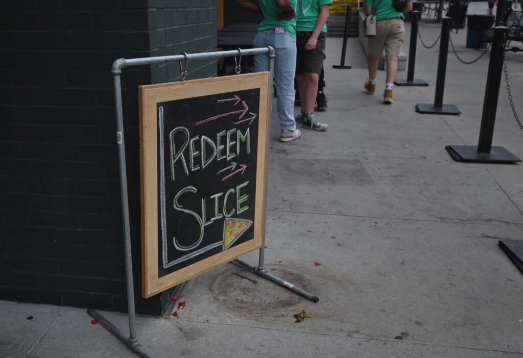 Chalkboard sign reads: Redeem slice.