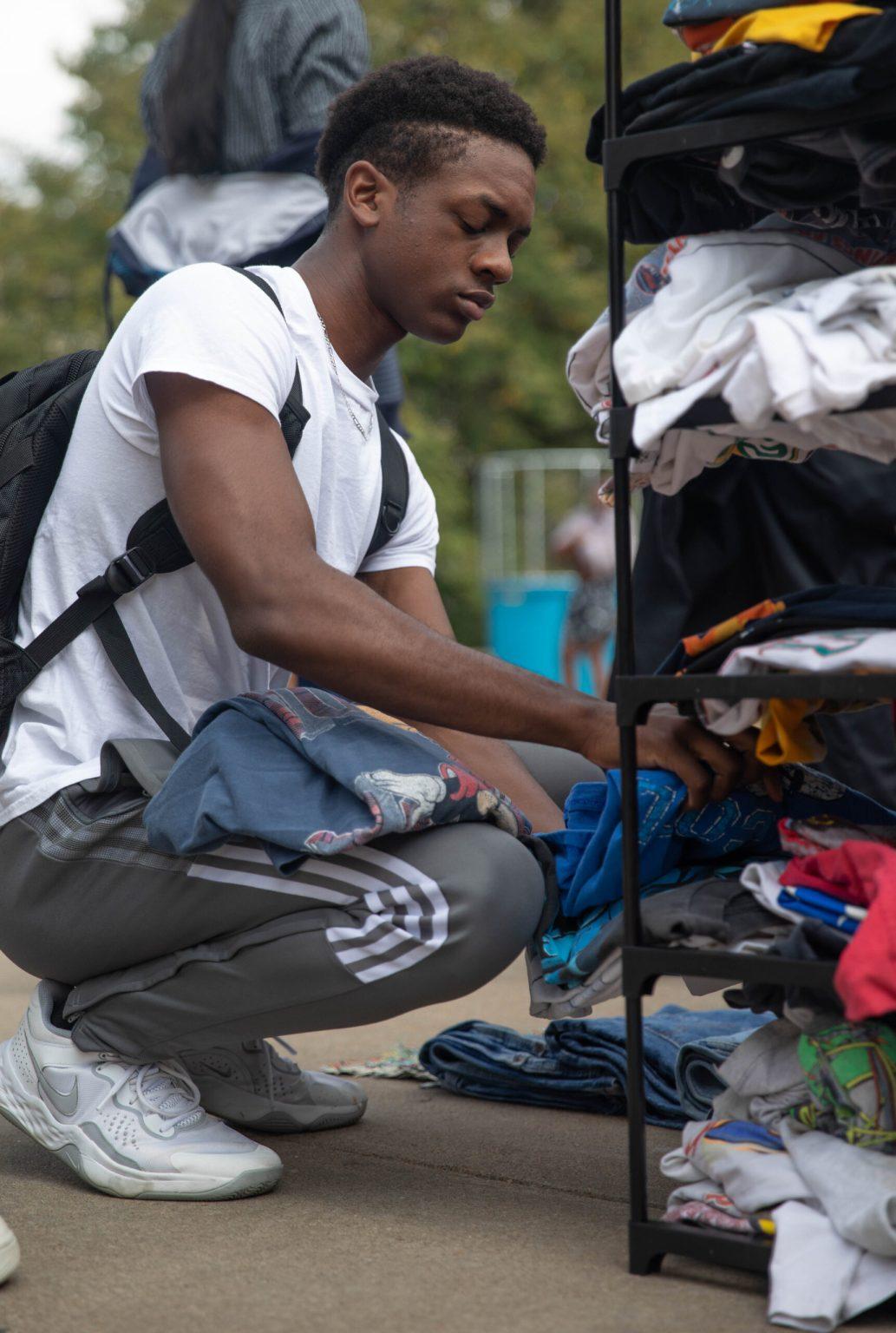 Daryus Shurn looks through a shelf of thrifted clothes at Speakers Circle.