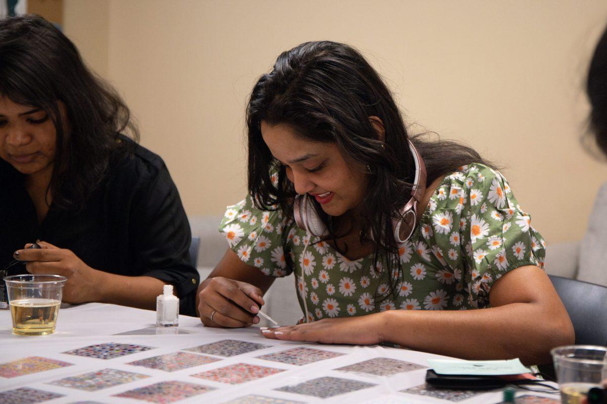 Sri Aishitha Koduru paints her nails on a white table with her friends.