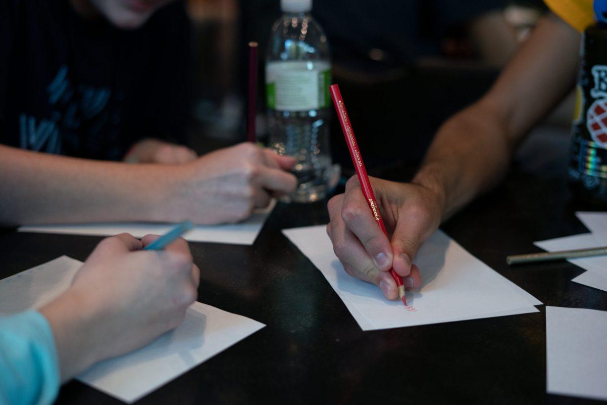 Close-up of students writing trivia answers
