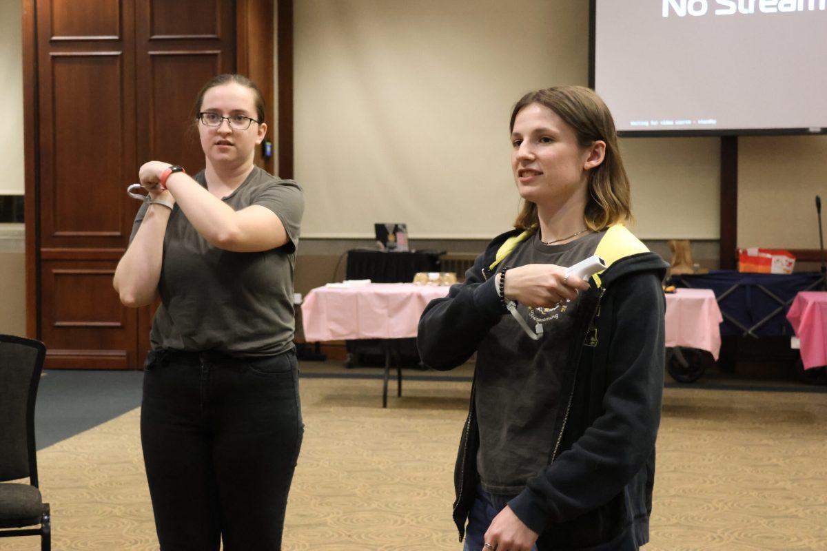 Two students playing a video game on a Wii.
