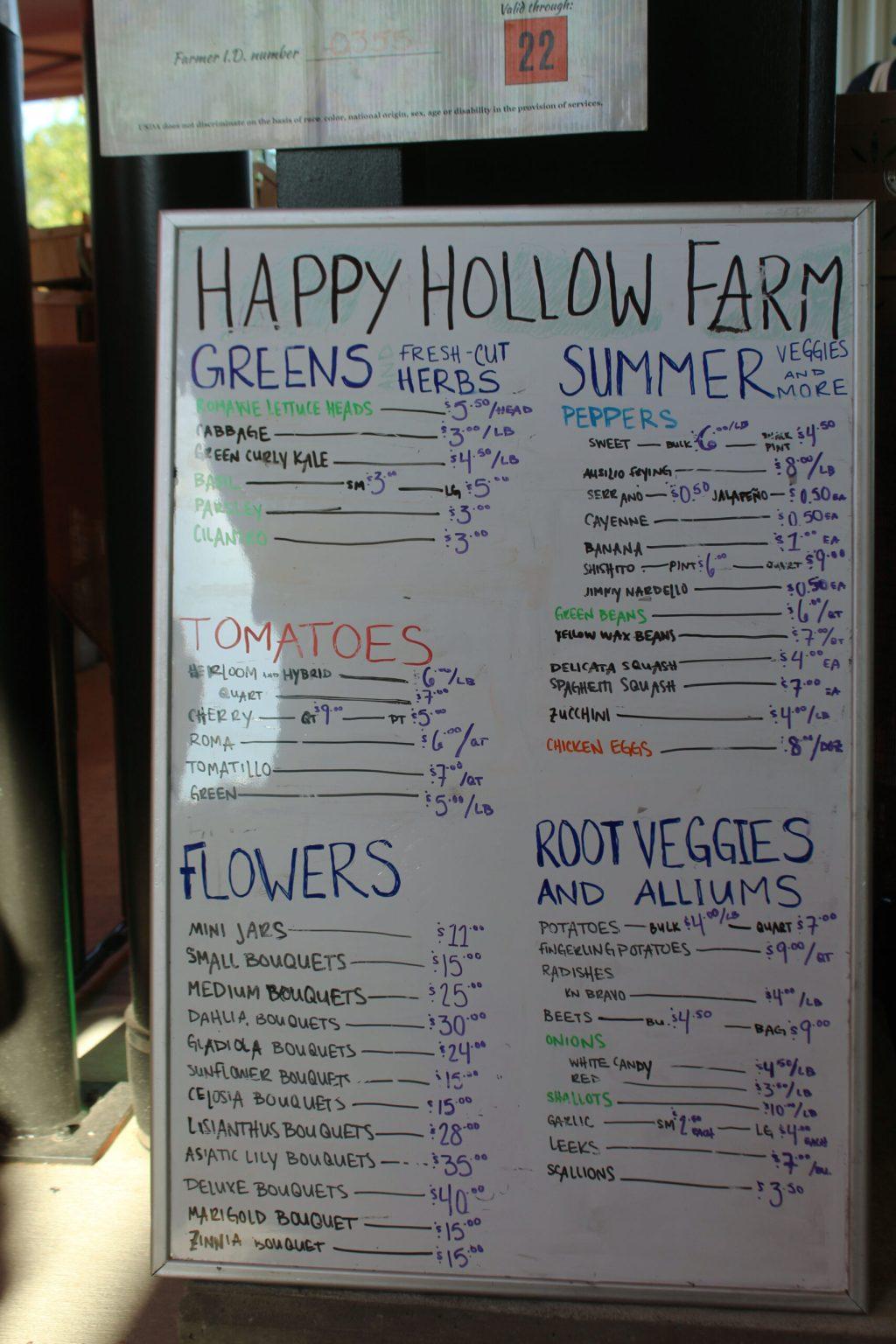 A whiteboard sign lists produce available for purchase.