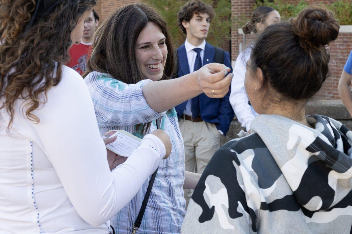 A woman reaches out to hug a girl.
