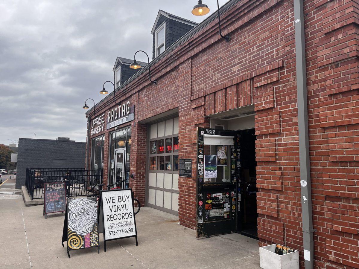 The brick storefront of Hitt Records, with a sign that says "we buy vinyl records."