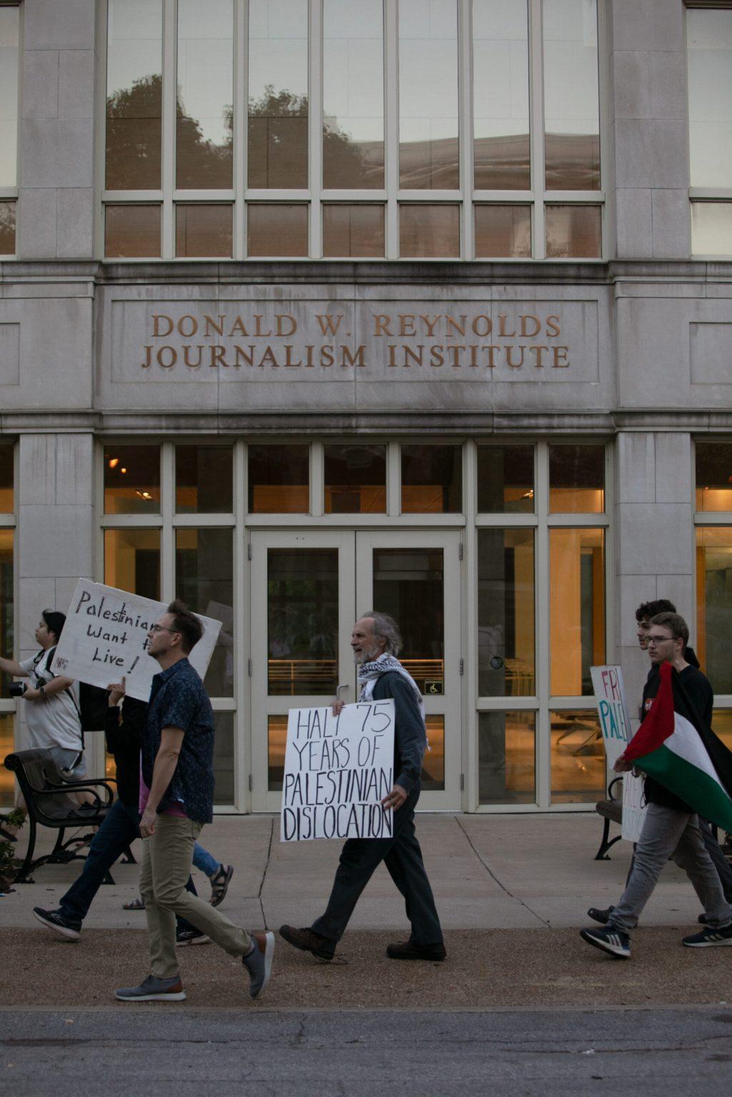 Jeff Stack carries sign past RJI building