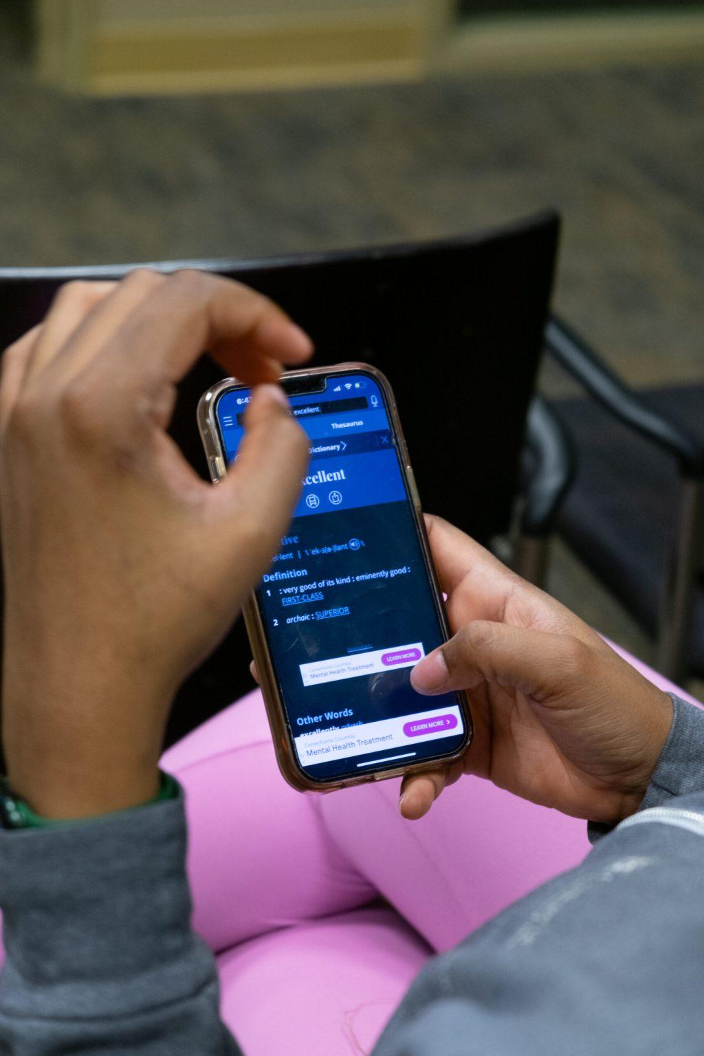 A woman holds her phone.
