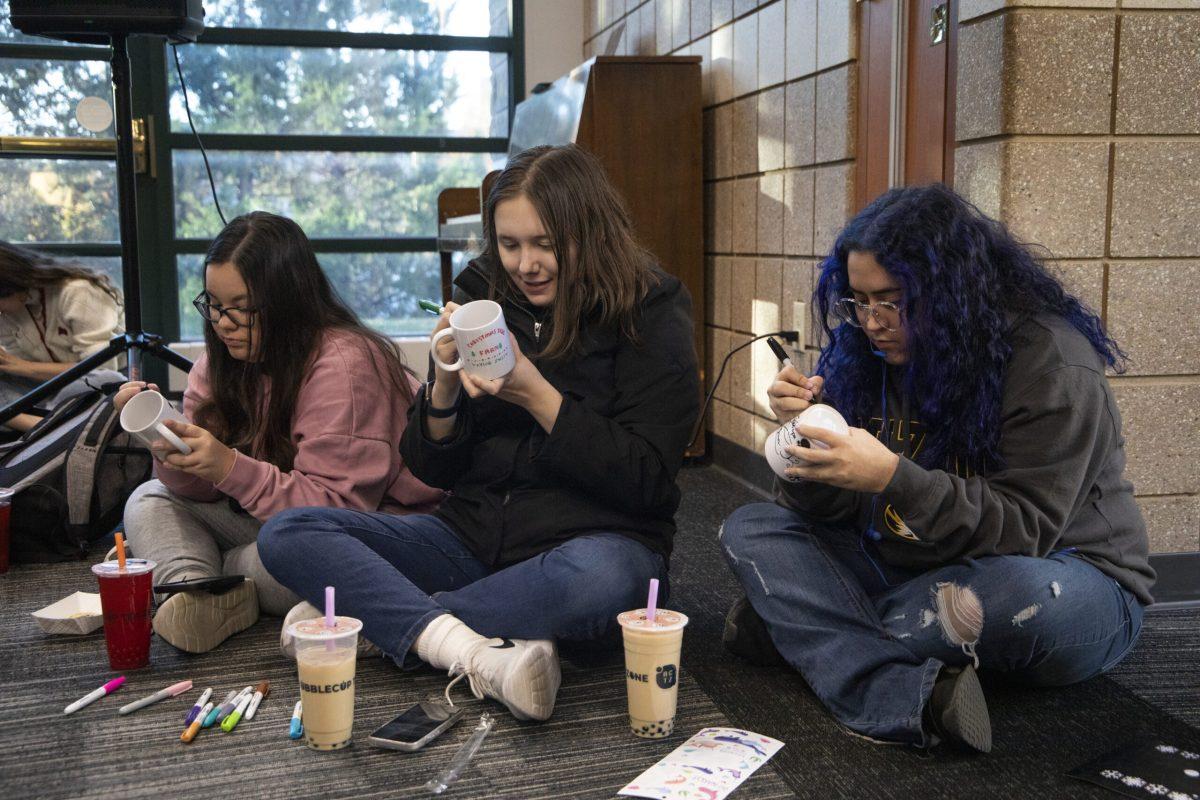 Freshmen Madison Preston, Emily Evans and Trinity Rodriguez write on their mugs.
