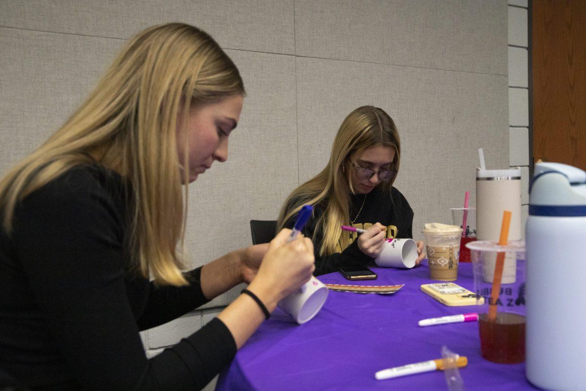Freshmen Louisa Martin and Sami Strayhorn decorate their mugs.
