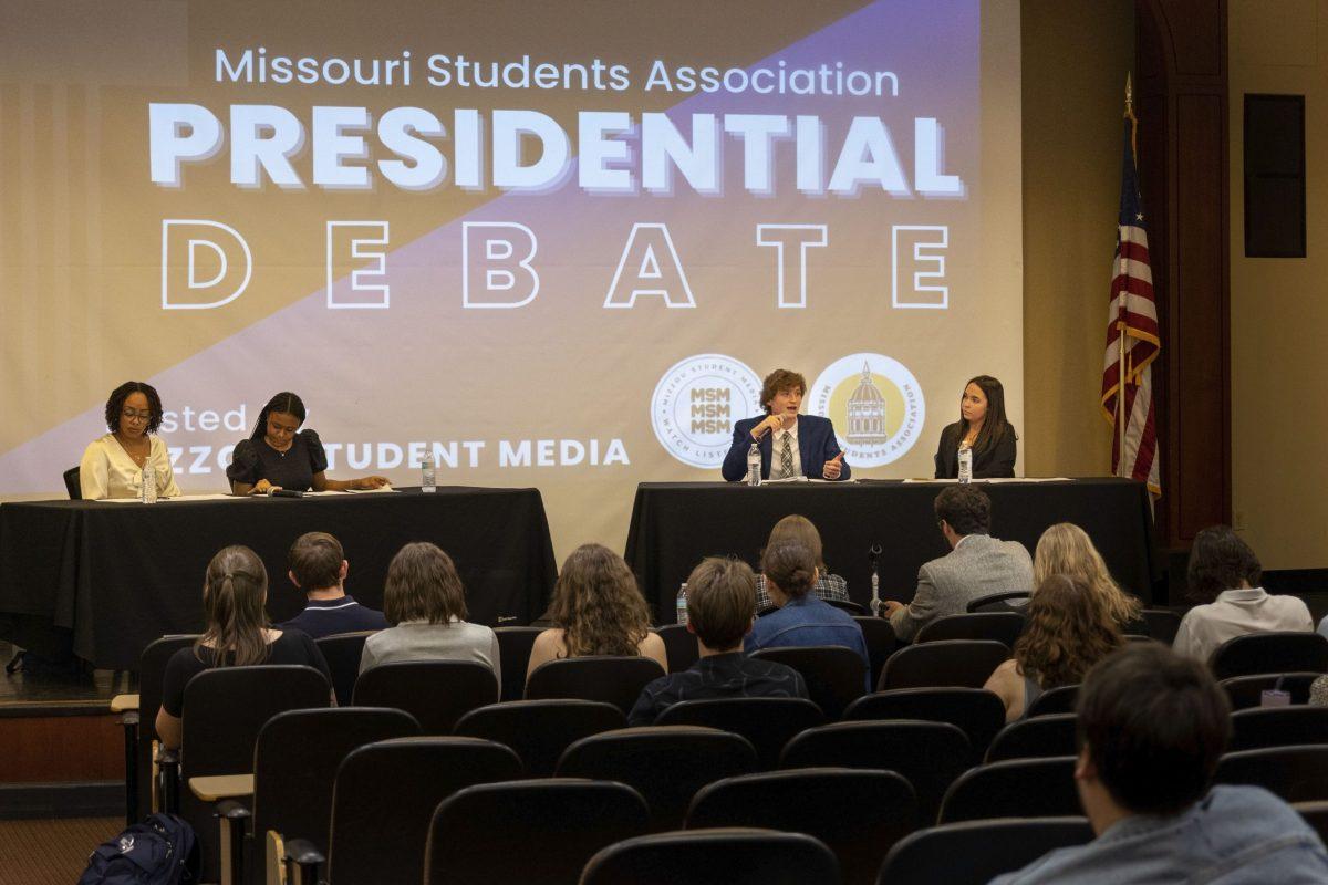 A man speaks into a microphone on stage as the background reads “Missouri Students Association presidential debate.”