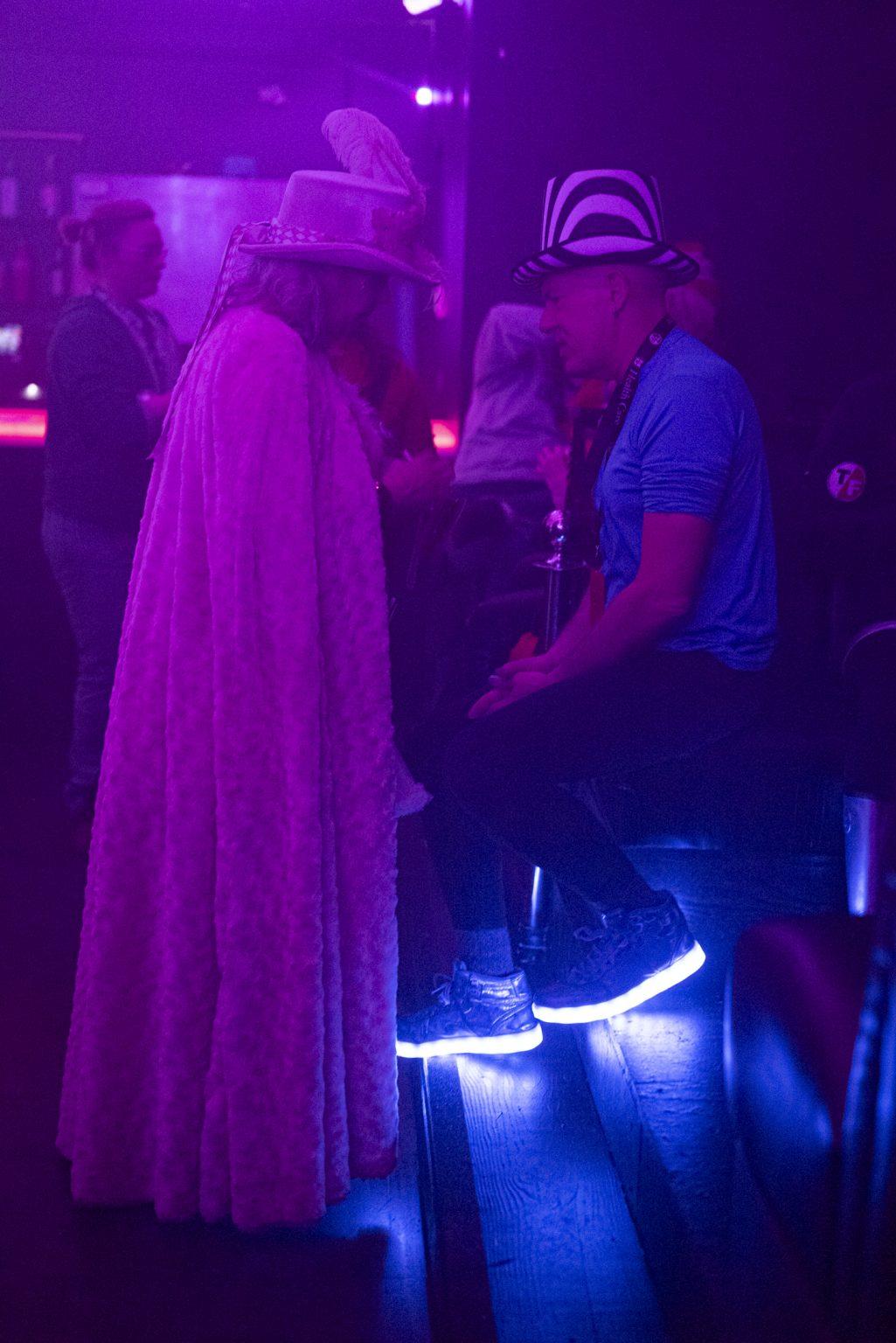 Two people share conversation at a bar.