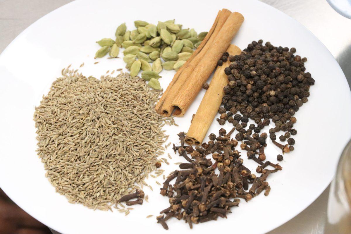 Cardamon, cinnamon, clove, black peppercorn and cumin on a plate in CoMo Cooks kitchen.