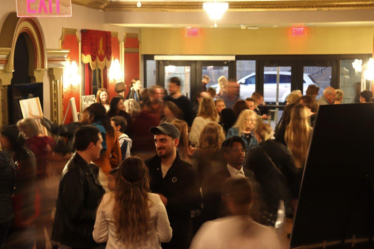 People walk across a crowded lobby.