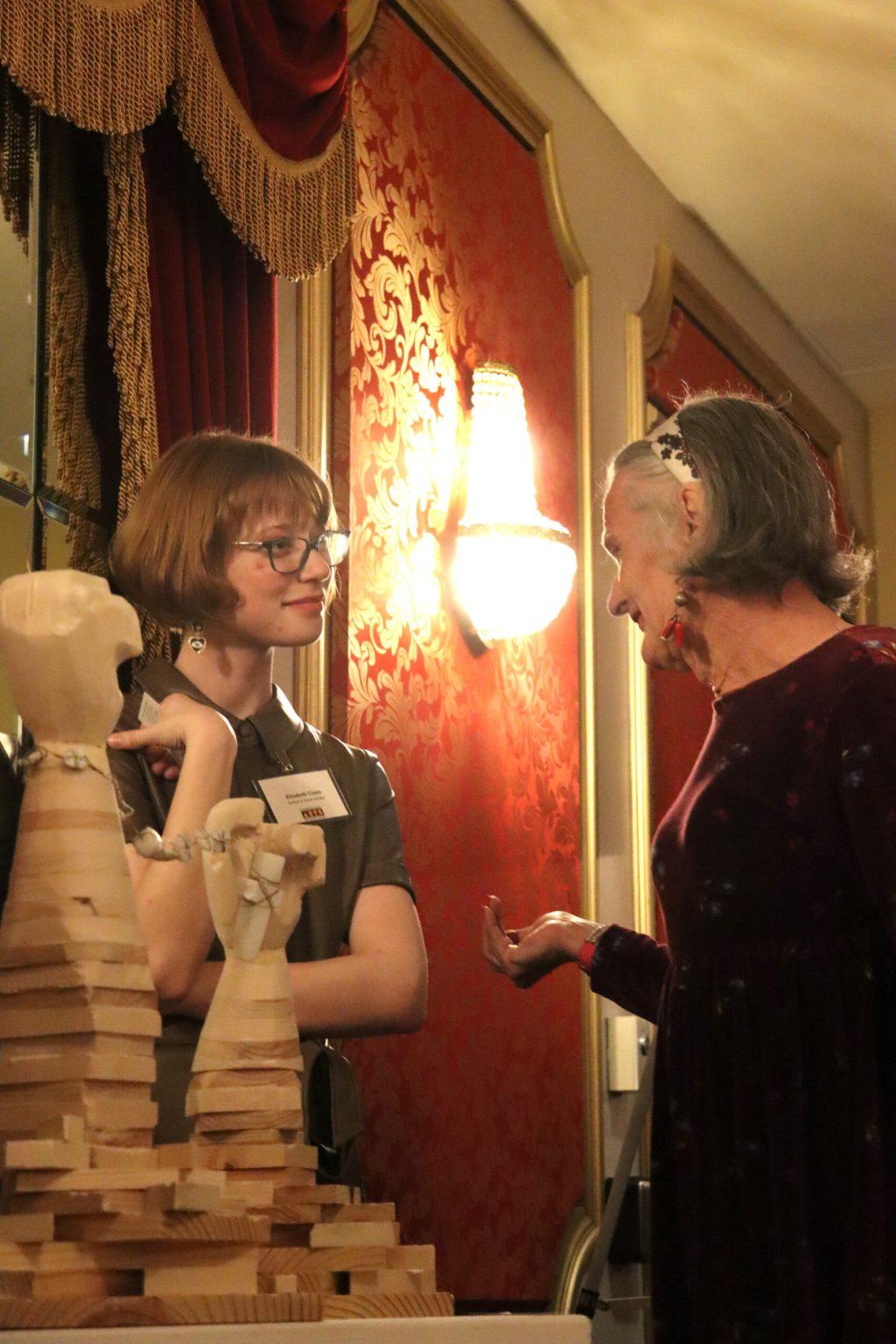 Artist discusses work with an event attendee.