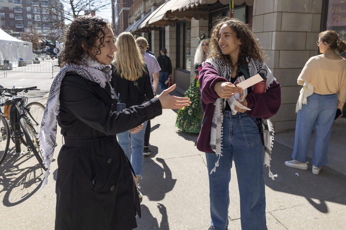 A woman hands a ticket to another woman. 