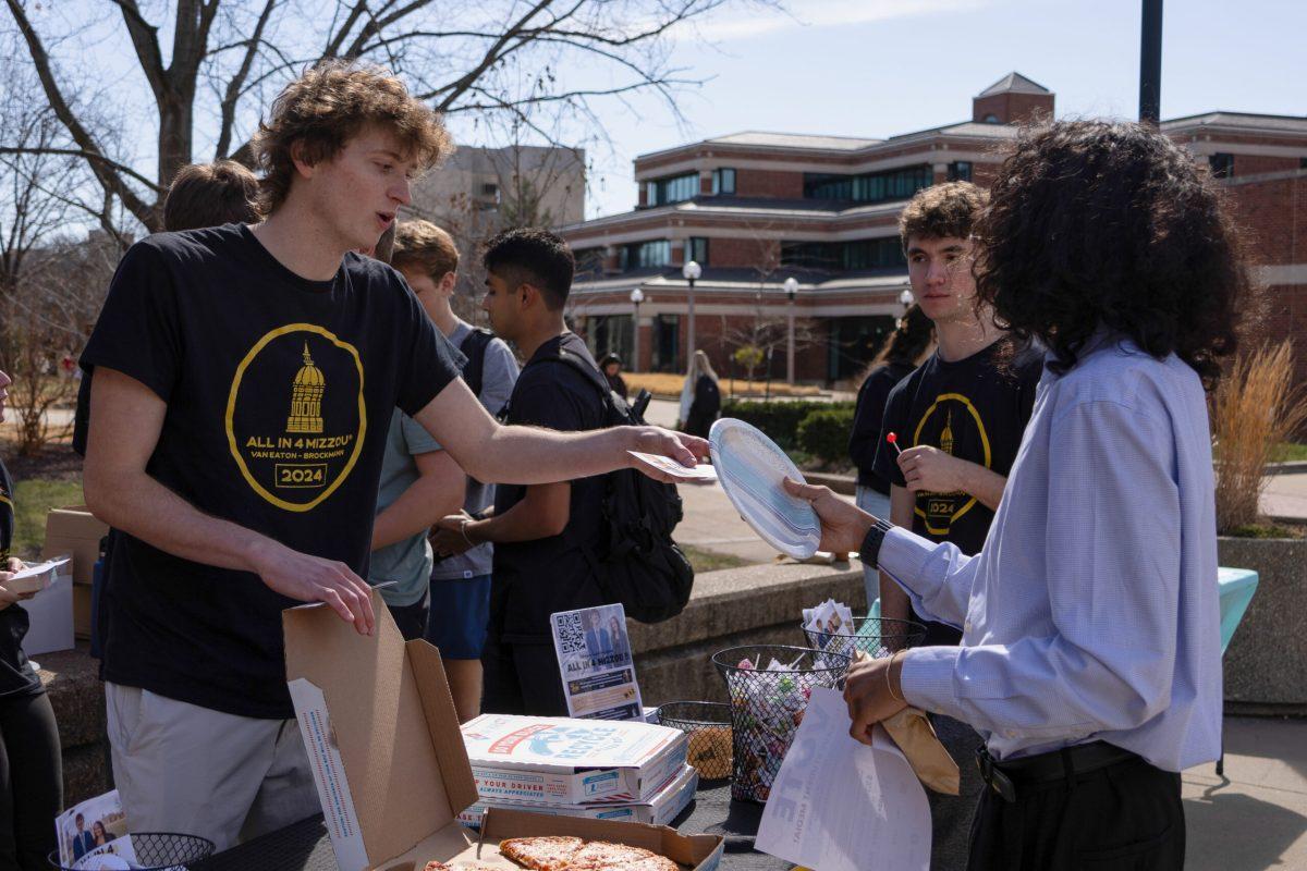 All in 4 Mizzou presidential candidate Clay Van Eaton handing a flier to a student.
