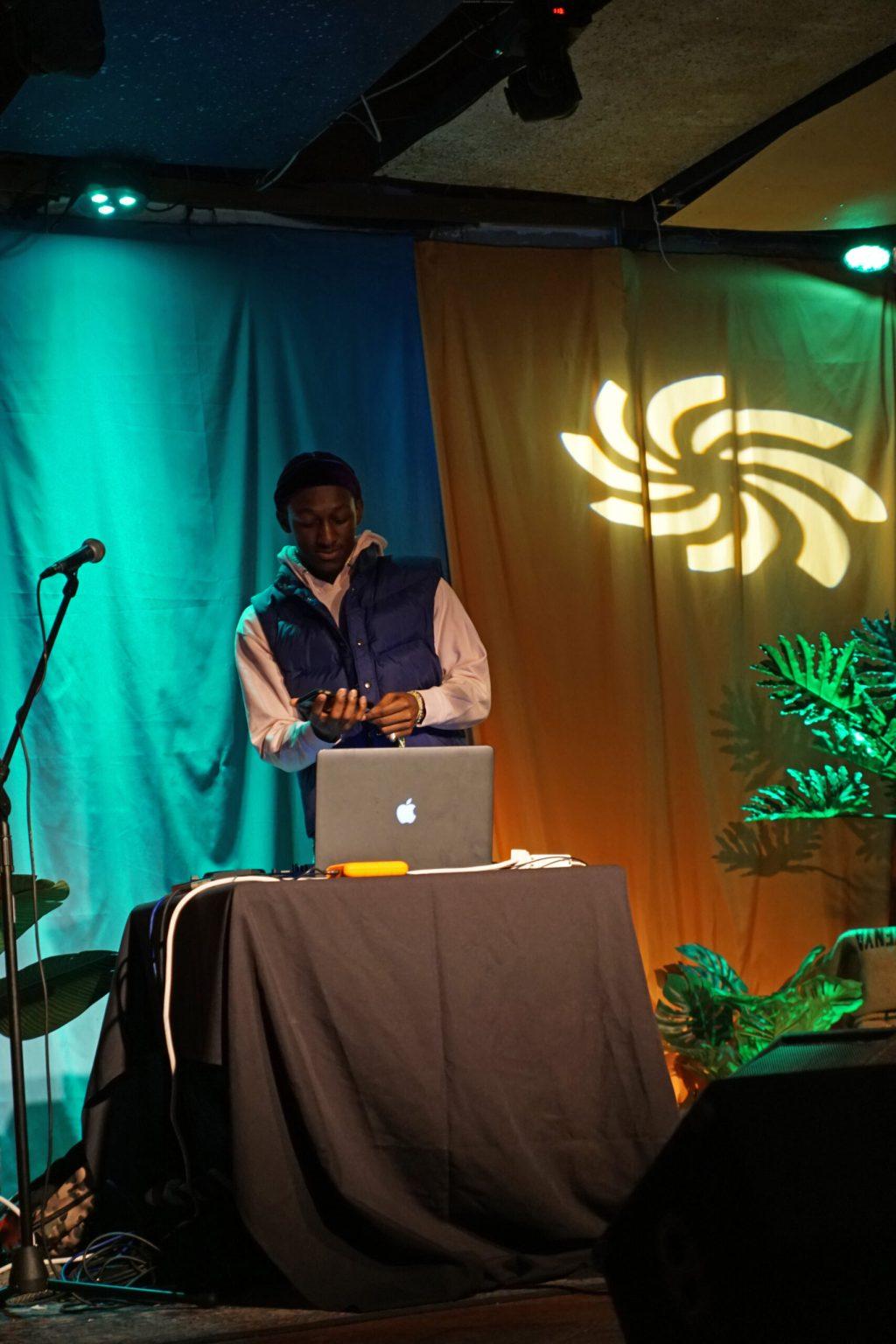 A man sets up his computer on a stage.