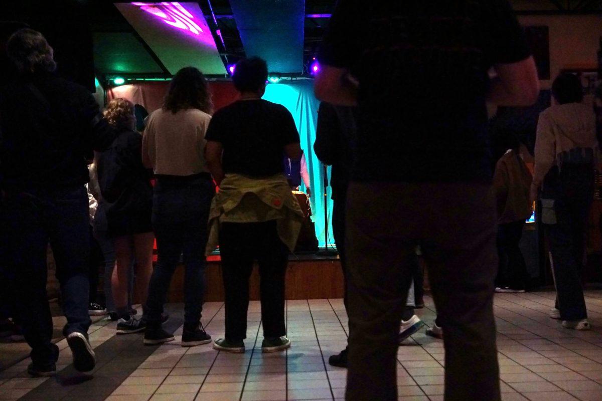 A crowd gathers and looks at the stage.