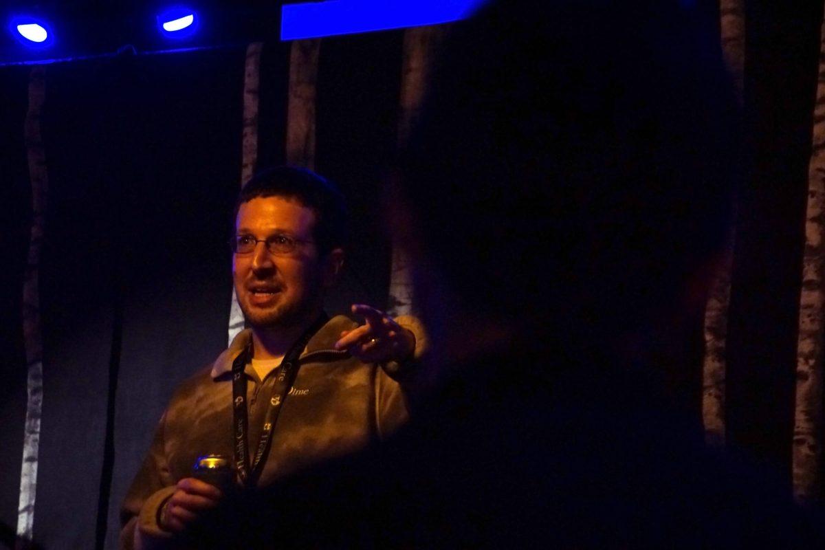 A man points while telling a crowd a story. 