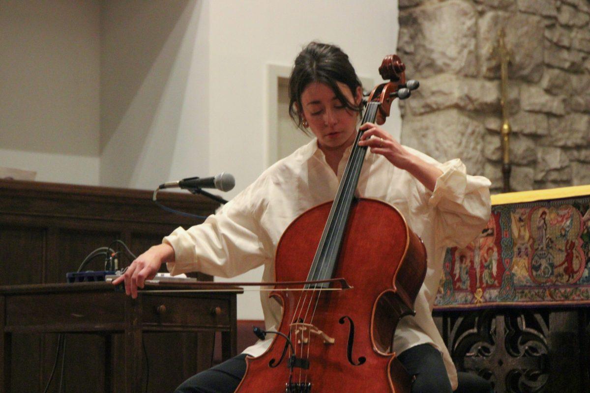 A woman is shown playing a cello. A mic is shown clipped to the bridge of the cello to capture the sound.