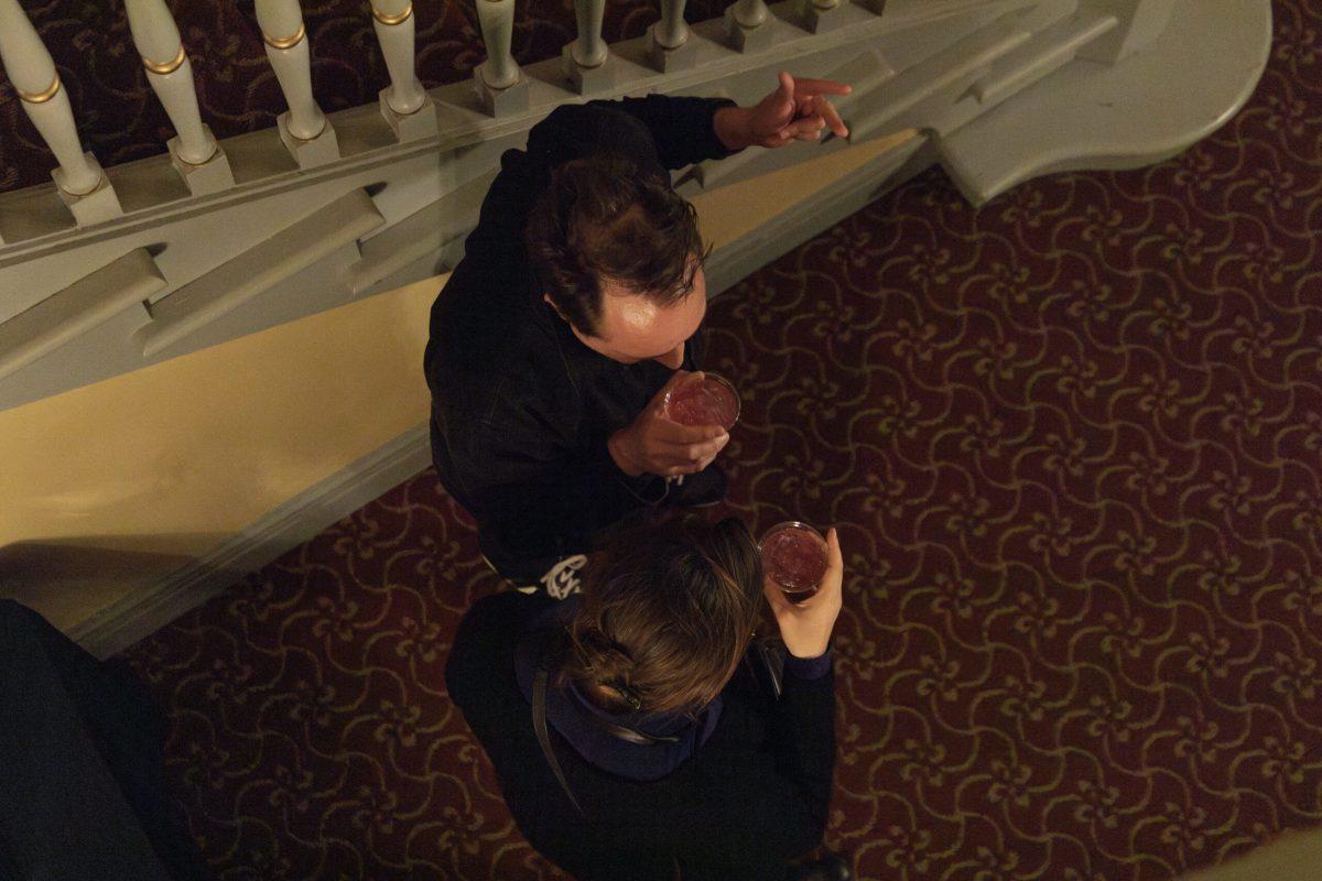 Two people hold cups.
