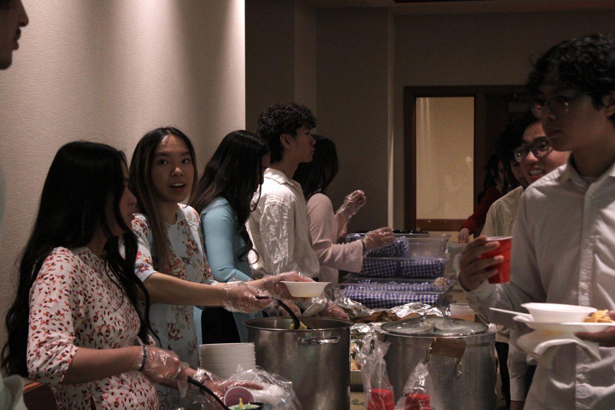 Sophomore Vy Vu and the executive board serve food to people.