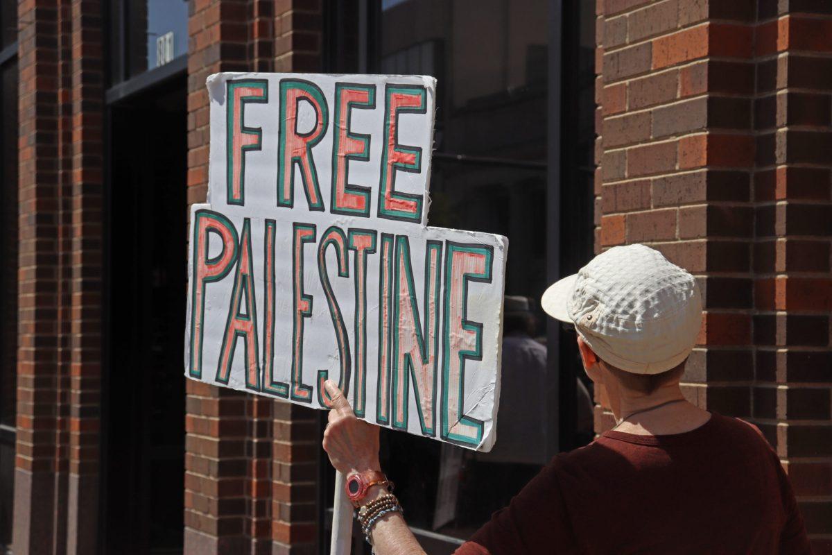 A protestor holds up a sign reading “Free Palestine”
