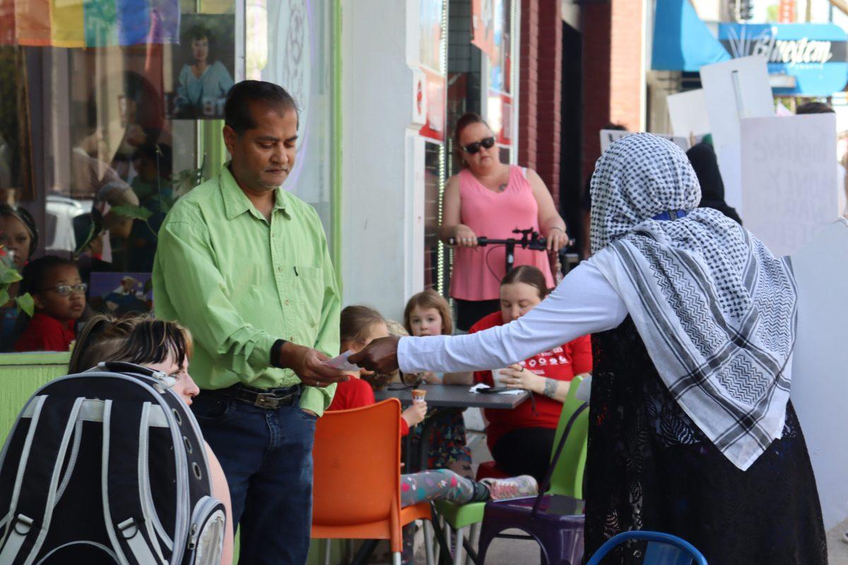 Protestor hands out papers to residents.