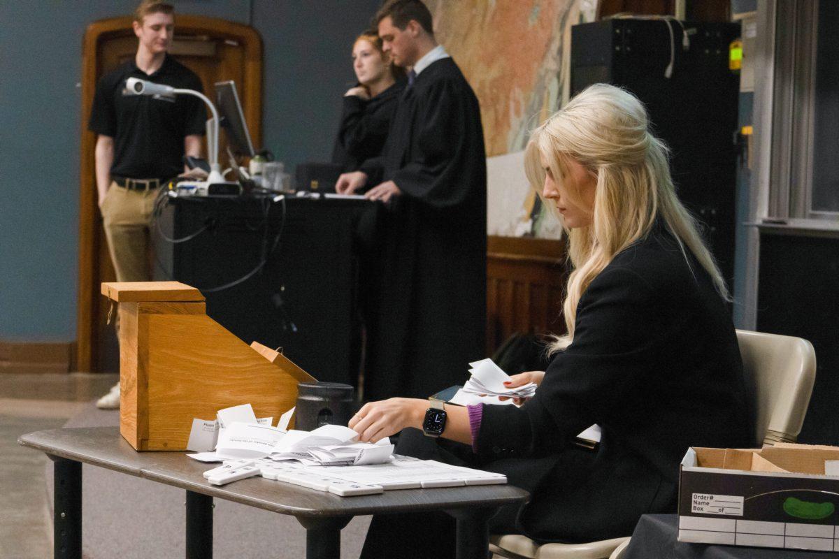 The Board of Election Commissioners Chair collecting paper ballots after the vote.