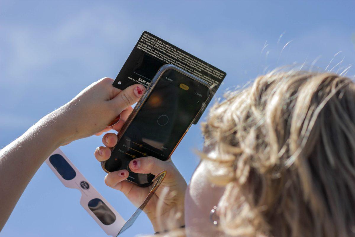 Girl taking photo of sun through lens
