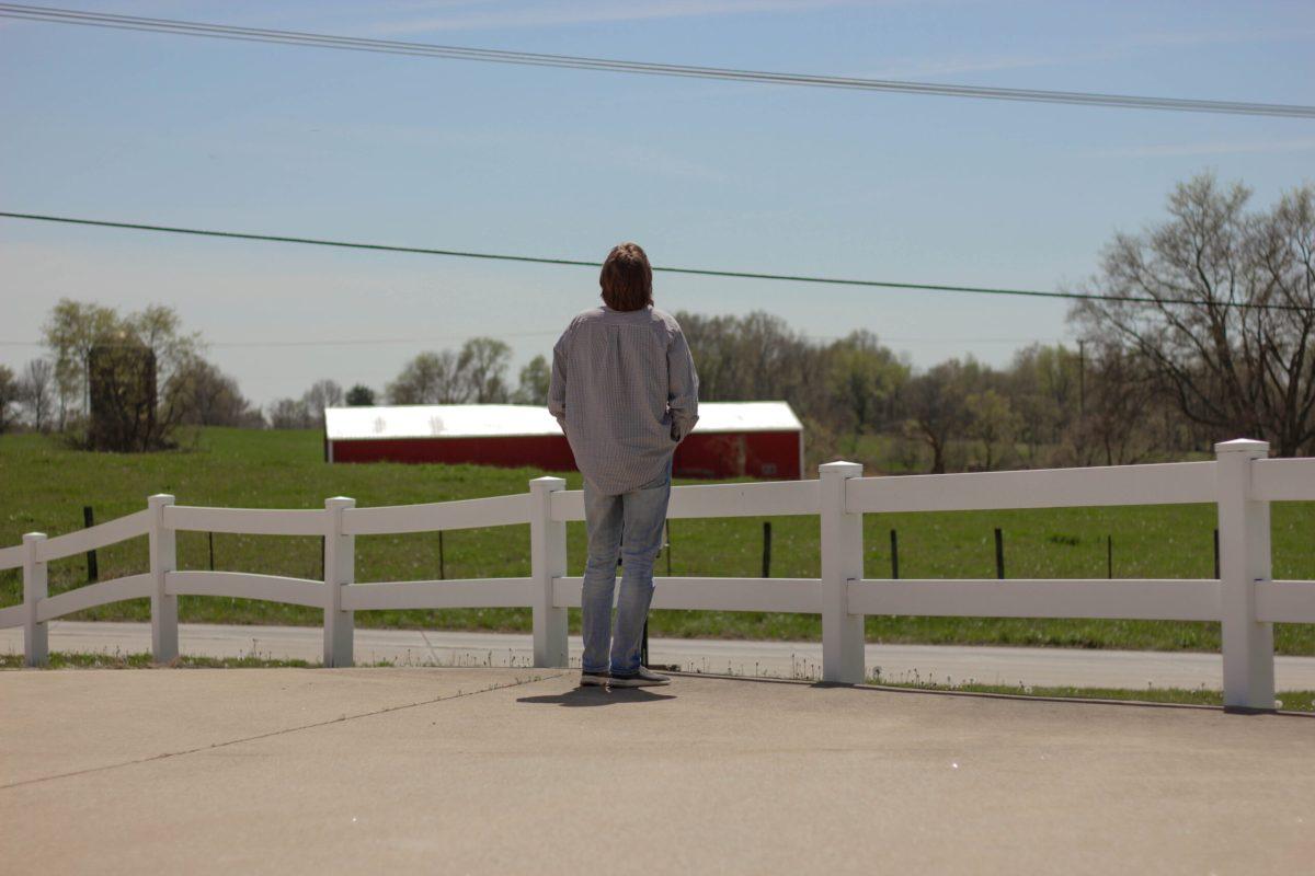 Man stands, looking at the sky.